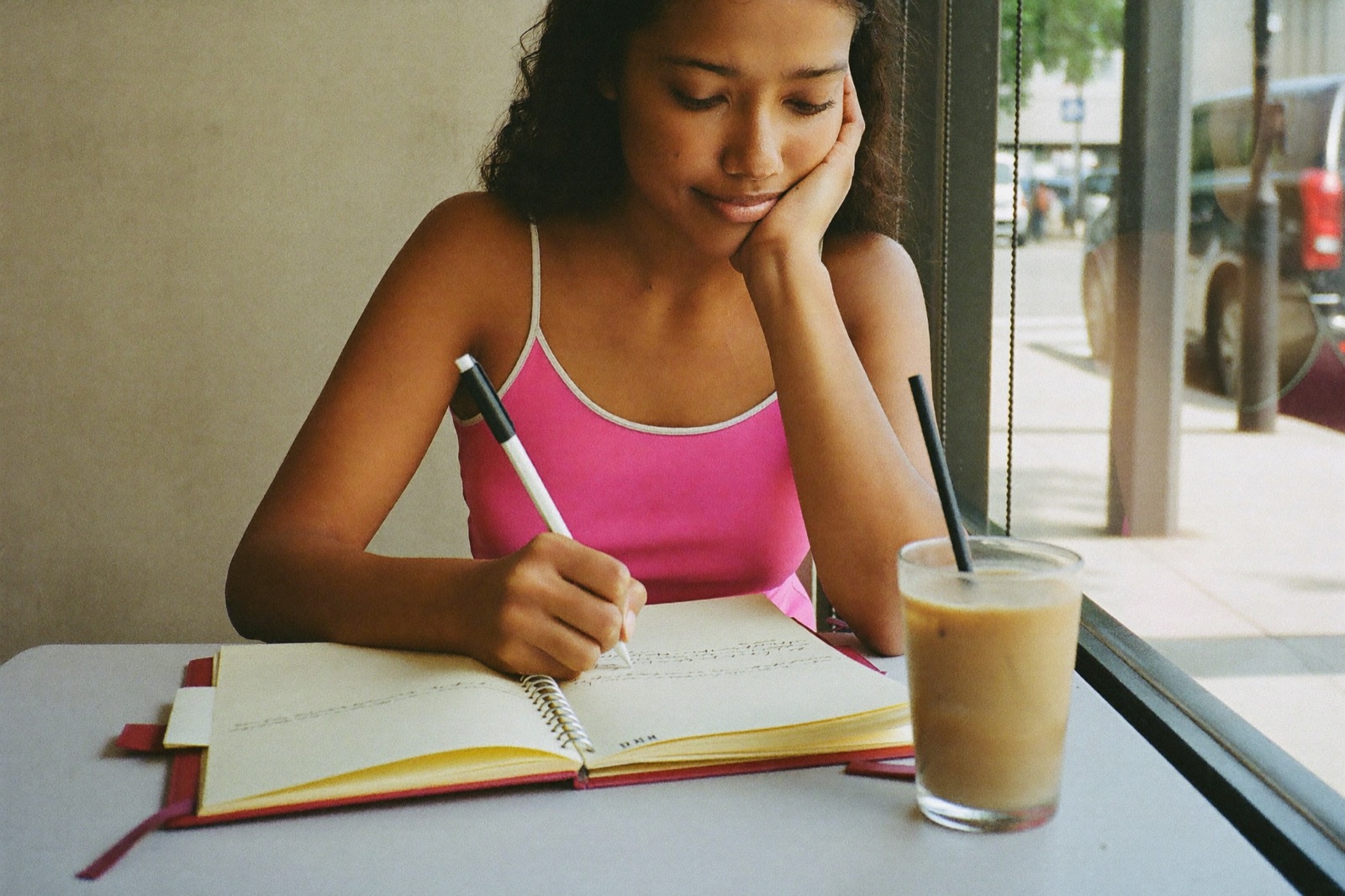 A young woman planning her week at a cafe